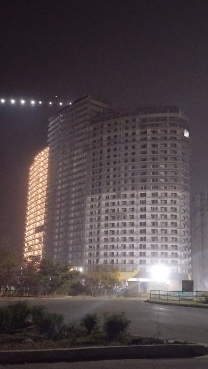 F Premiere Tower A unlit at the rear compared with the finished, lit Tower C, Kharghar, Navi Mumbai